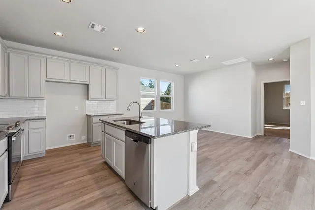 a kitchen with granite countertop a stove and a sink