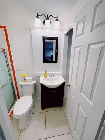 a bathroom with a sink and mirror with toilet