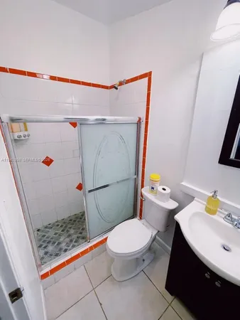 a white toilet sitting next to a bathroom sink and a shower