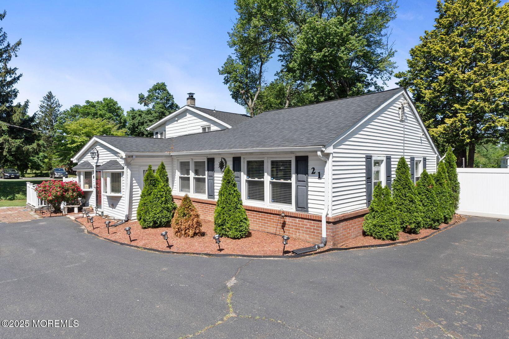 21 Wickatunk Road Manalapan, NJ 07726 - Photo 2 of 48 a front view of a house with a garden and plants