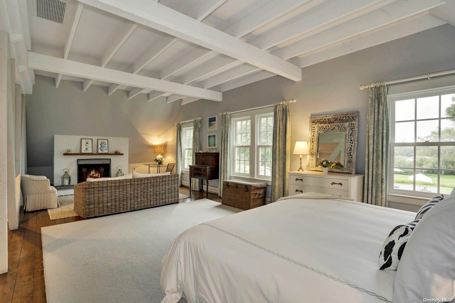 5 Shinnecock Road Quogue, NY 11959 - Photo 21 of 35 a spacious bedroom with a large bed and a fireplace