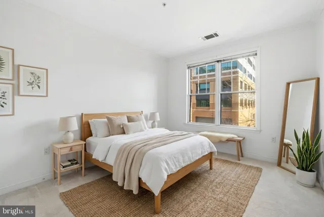 a bedroom with a large bed and a potted plant