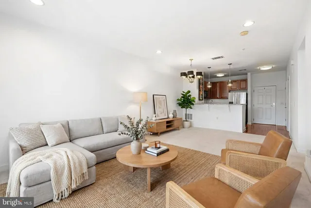 a living room with furniture and a view of kitchen