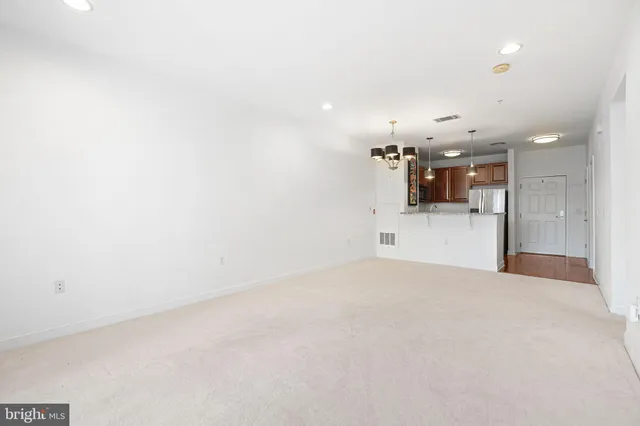 an empty room with kitchen and window