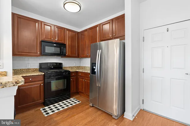 a kitchen with granite countertop a refrigerator stove and microwave