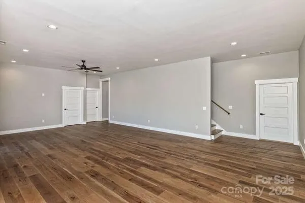 a view of a room with wooden floor and ceiling fan
