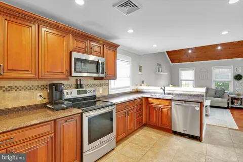 a kitchen with a sink a counter top space stainless steel appliances and a window