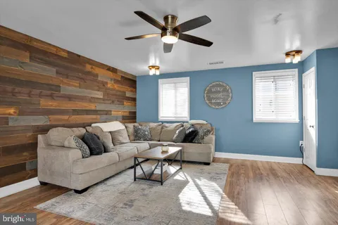 a living room with furniture and a flat screen tv with kitchen view