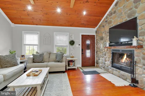 a living room with furniture a flat screen tv and a fireplace