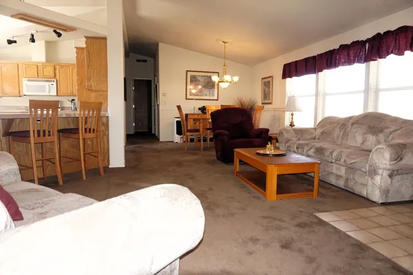 a living room with furniture a large window and a chandelier