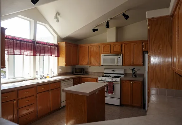 a kitchen with a sink stove top oven and refrigerator