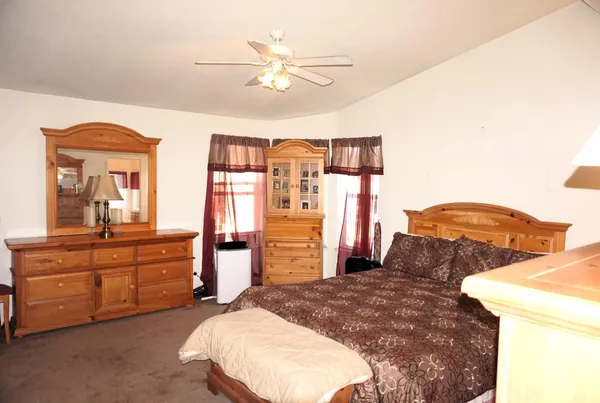 a bedroom with a bed and dresser with mirror