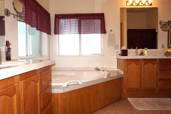 a bathroom with a tub sink and mirror
