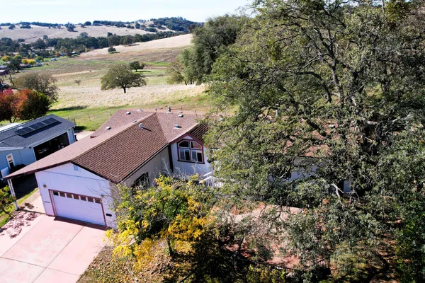 an aerial view of a house with a yard and lake view
