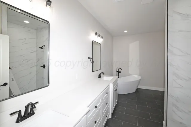 a spacious bathroom with double vanity and mirrors