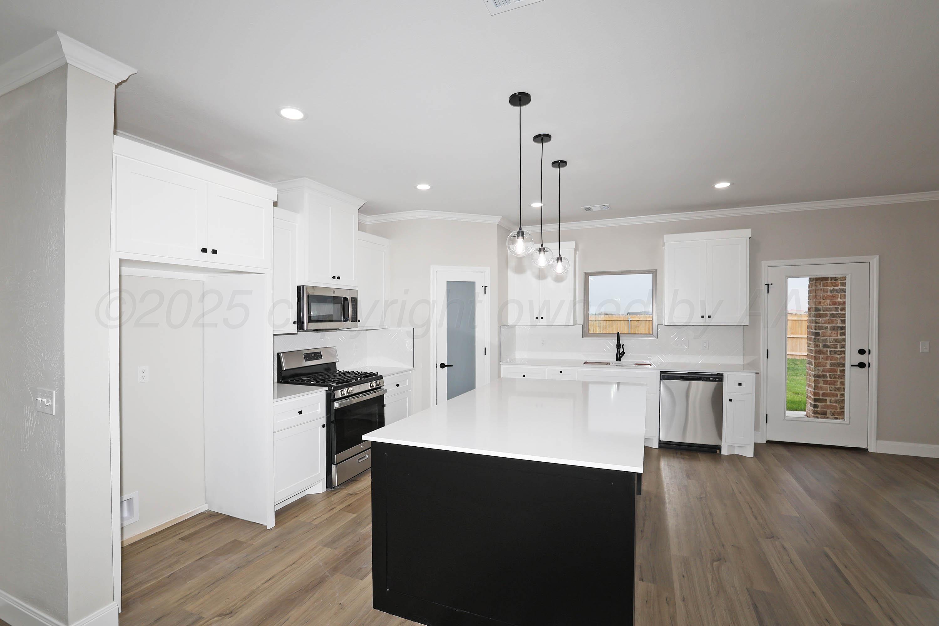 18150 Mid-Country Boulevard Amarillo, TX 79119 - Photo 8 of 25 a kitchen with a refrigerator a sink and wooden floor