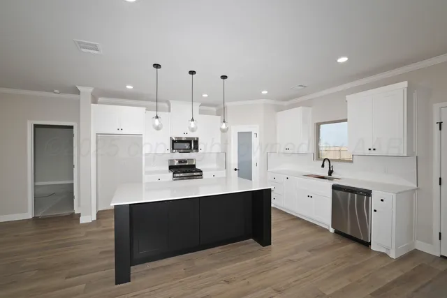 a kitchen with stainless steel appliances sink refrigerator and cabinets