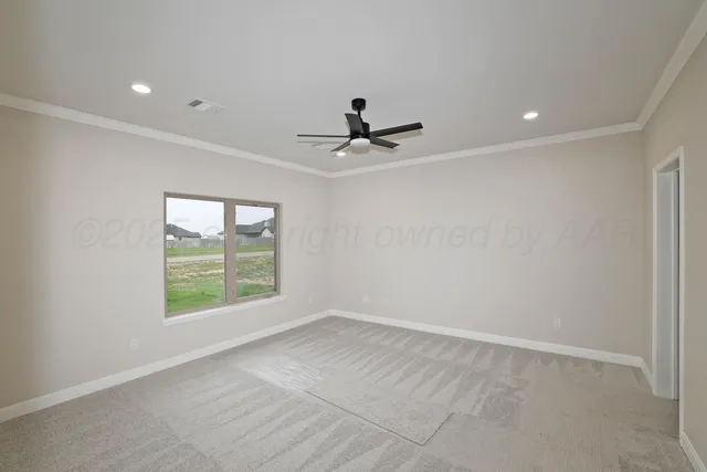 an empty room with windows and ceiling fan