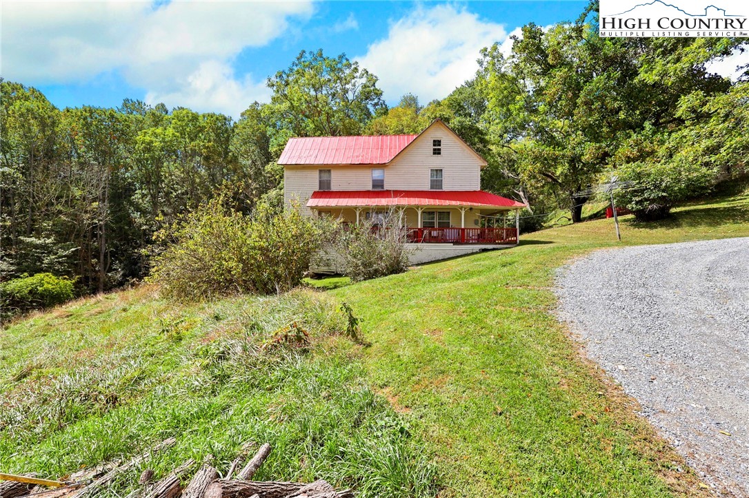 423 Beaver Dam Farm Road Vilas, NC 28692 - Photo 14 of 15 a front view of a house with a yard and trees