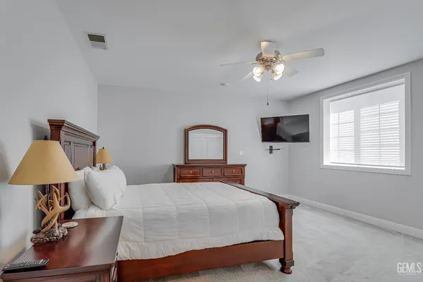 a bedroom with bed tv and window