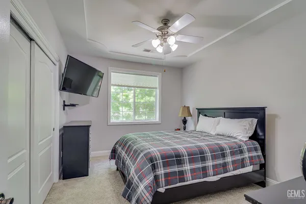a bedroom with a large bed and a flat tv screen on a dresser