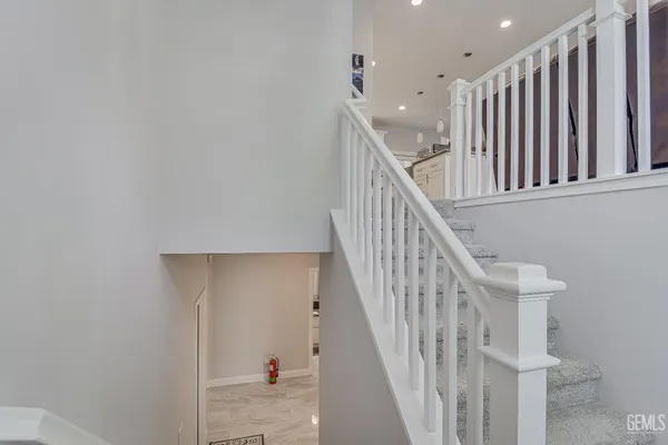a view of staircase with railing and white walls