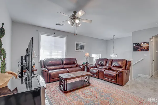 a living room with furniture a flat screen tv and a large window