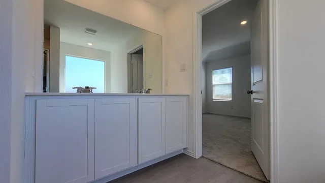 a view of a hallway and a livingroom with a bathroom