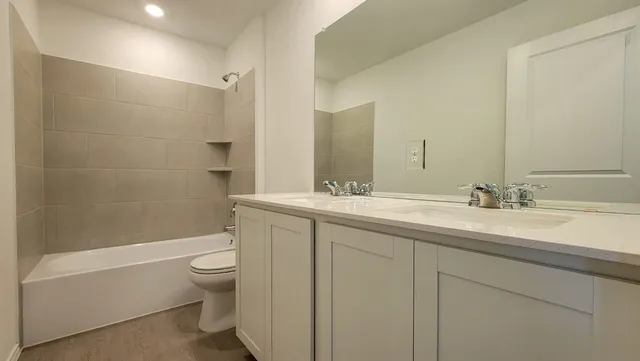 a bathroom with a double vanity sink toilet and shower