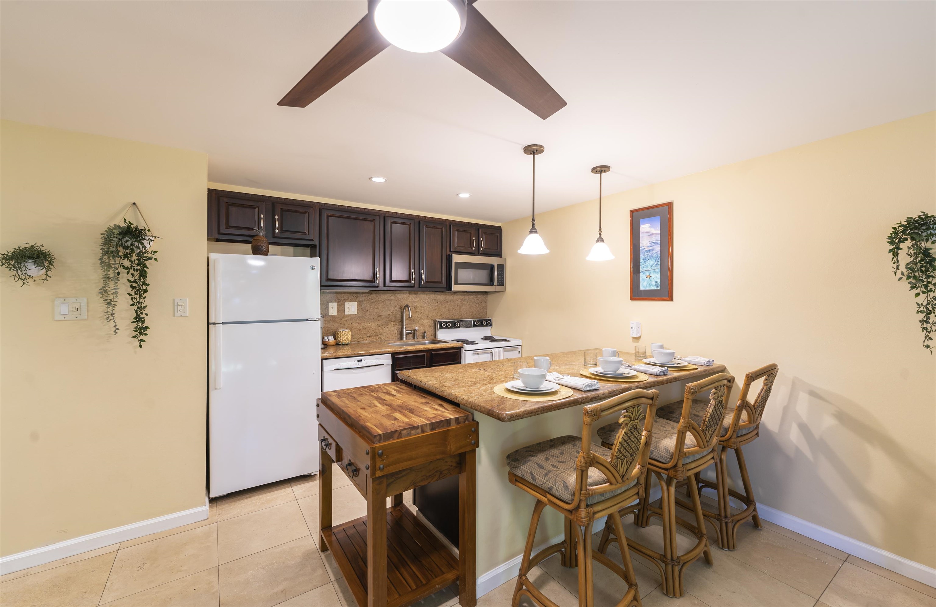 2495 South Kihei Road, Unit 137 Kihei, HI 96753 - Photo 6 of 17 a kitchen with stainless steel appliances kitchen island granite countertop a dining table and chairs