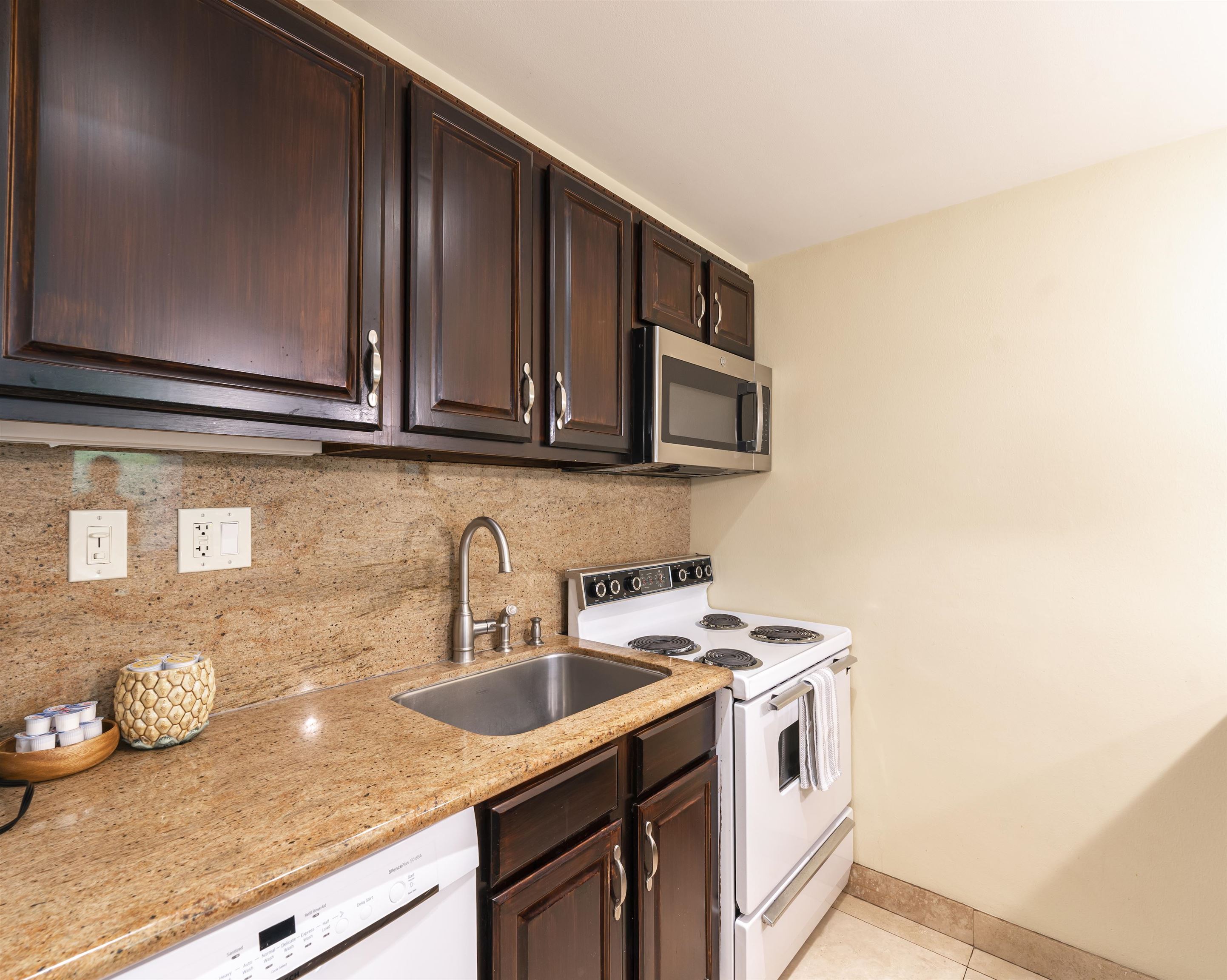 2495 South Kihei Road, Unit 137 Kihei, HI 96753 - Photo 7 of 17 a kitchen with stainless steel appliances granite countertop a sink a stove and a microwave