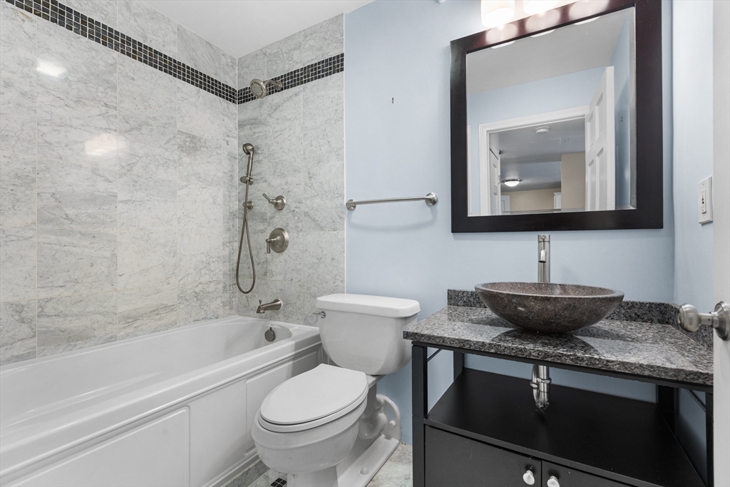 42 8th Street, Unit 4209 Boston, MA 02129 - Photo 13 of 15 a bathroom with a granite countertop sink a toilet and bathtub