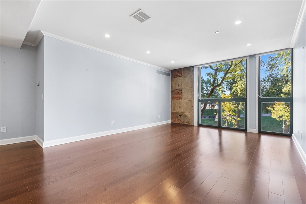 42 8th Street, Unit 4209 Boston, MA 02129 - Photo 3 of 15 a view of an empty room with wooden floor and a window
