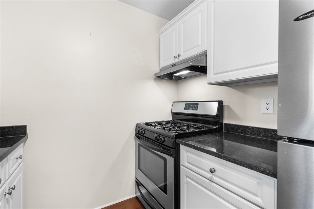 42 8th Street, Unit 4209 Boston, MA 02129 - Photo 6 of 15 a kitchen with granite countertop white cabinets and a stove