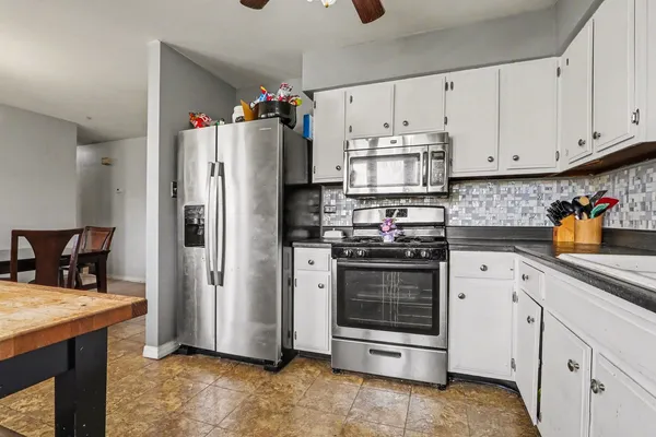 a kitchen with stainless steel appliances a stove refrigerator and cabinets