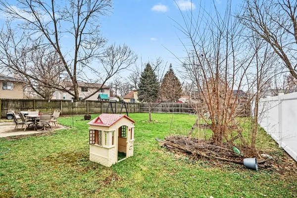 a front view of a house with garden and trees