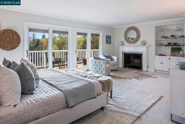 a bedroom with a bed a fireplace and a large window