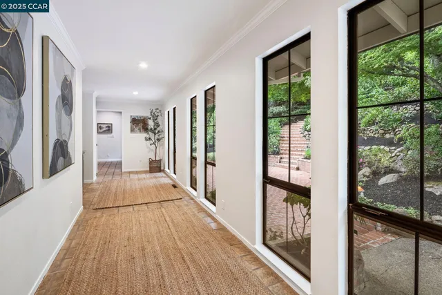 a view of a hallway with wooden floor and windows