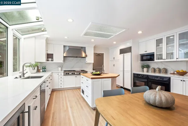 a kitchen with stainless steel appliances kitchen island granite countertop a stove refrigerator and cabinets