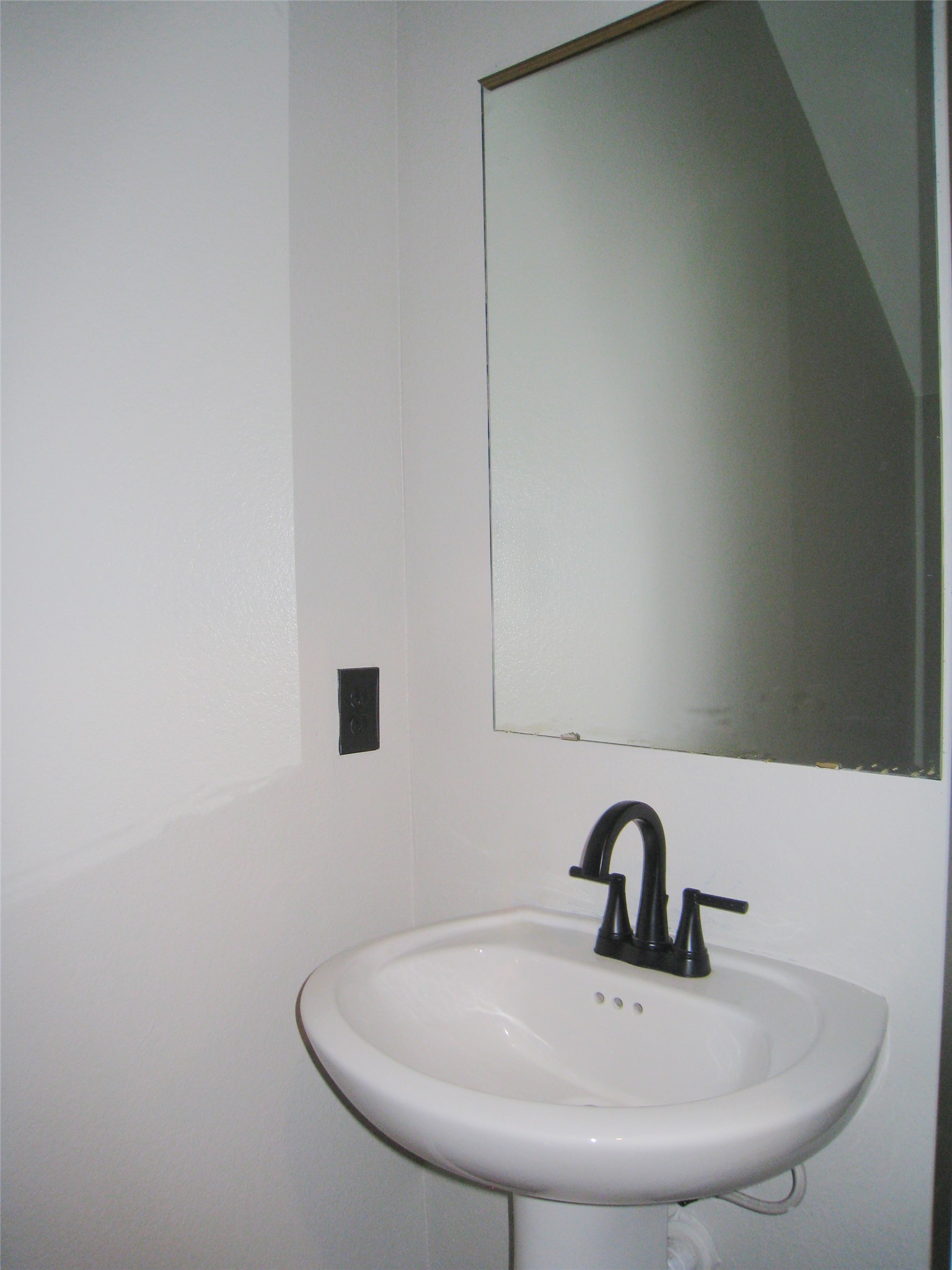 229 Geode Glen Maxwell, TX 78656 - Photo 9 of 19 A pristine pedestal sink paired with a contemporary dark faucet offers a sleek bathroom design.