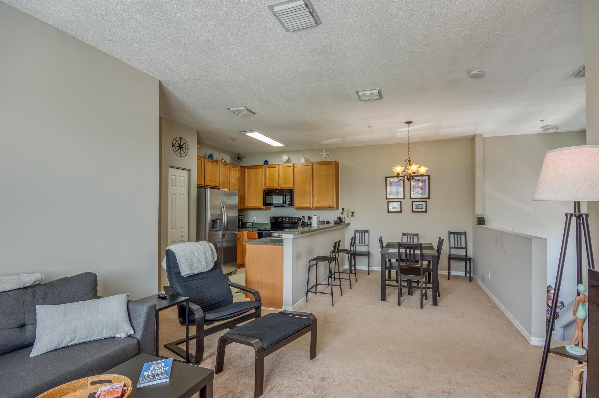 112 Lighthouse Circle, Unit J Tequesta, FL 33469 - Photo 8 of 22 a living room with furniture a dining table and a piano