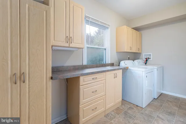 a utility room with cabinets washer and dryer