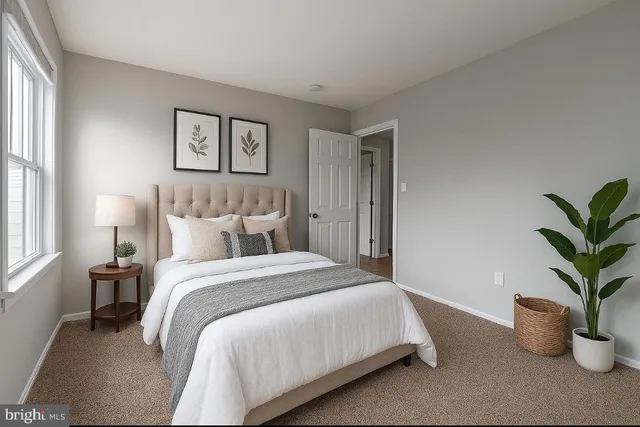 a bedroom with a large bed and a potted plant