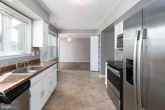 a kitchen with granite countertop a refrigerator and a sink