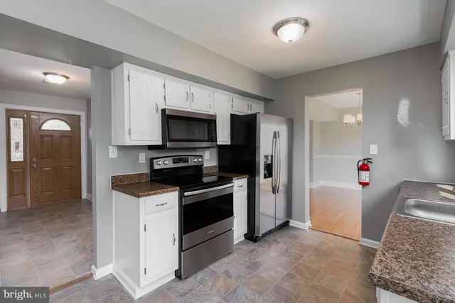 a kitchen with granite countertop a refrigerator and a sink