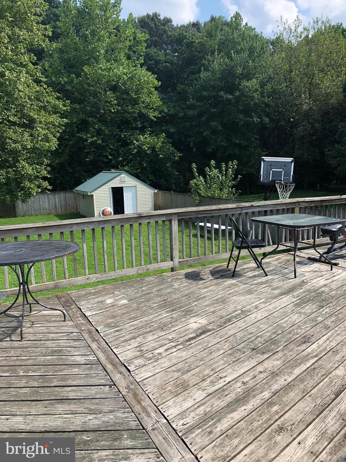 8121 Hog Neck Road Pasadena, MD 21122 - Photo 3 of 8 a view of a deck with chair and wooden floor