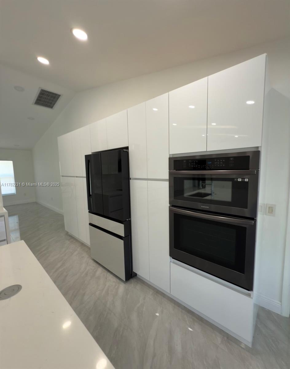 16911 Southwest 66th Street Southwest Ranches, FL 33331 - Photo 13 of 70 a kitchen with stainless steel appliances a stove and a microwave