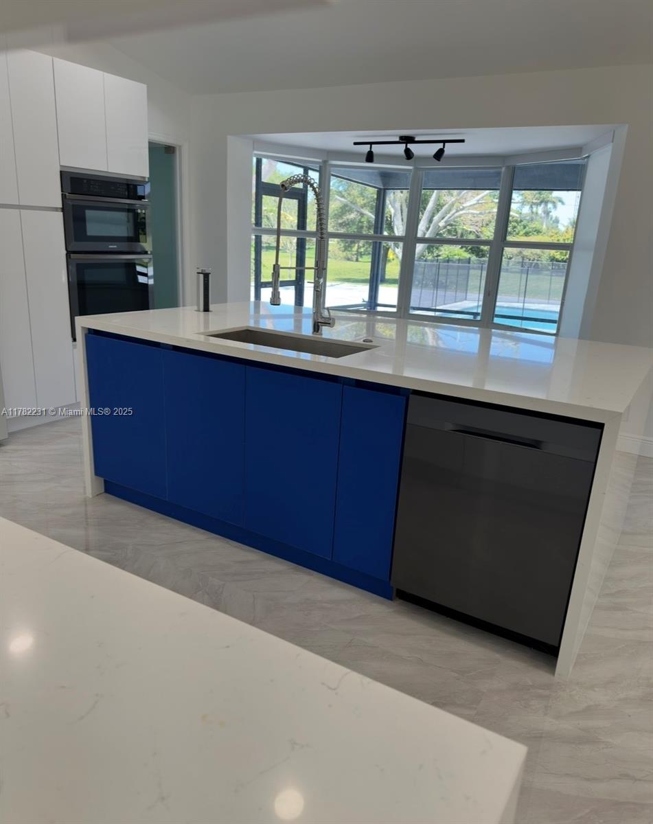 16911 Southwest 66th Street Southwest Ranches, FL 33331 - Photo 14 of 70 a kitchen with stainless steel appliances granite countertop a stove a sink and a microwave