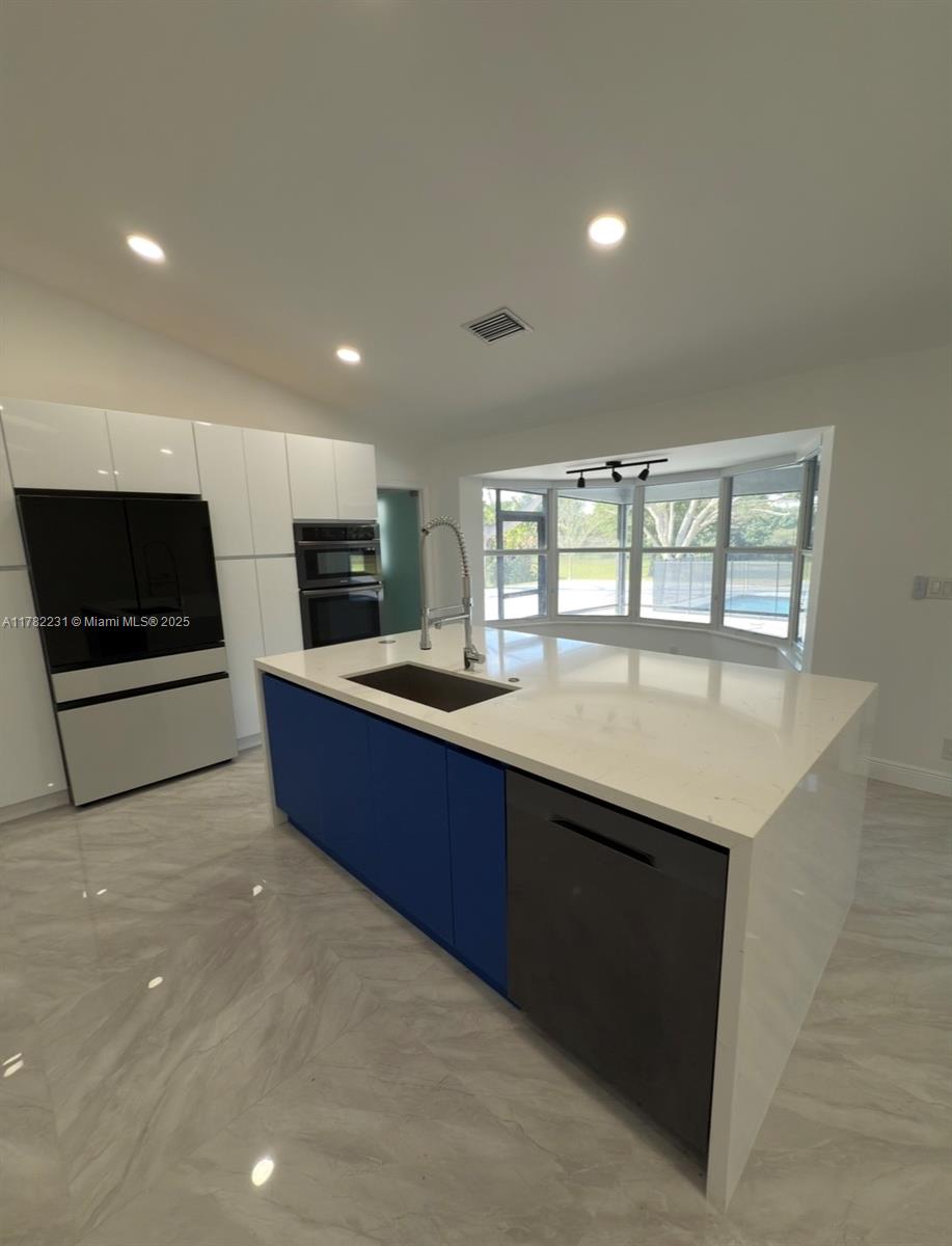 16911 Southwest 66th Street Southwest Ranches, FL 33331 - Photo 18 of 70 a large kitchen with stainless steel appliances a large counter top and a stove