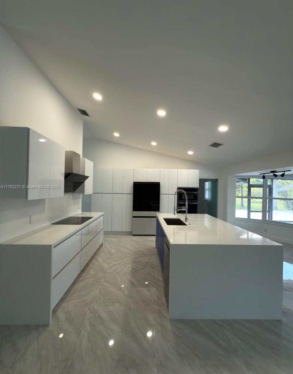 16911 Southwest 66th Street Southwest Ranches, FL 33331 - Photo 20 of 70 a large white kitchen with kitchen island a sink a counter top space stainless steel appliances and a window
